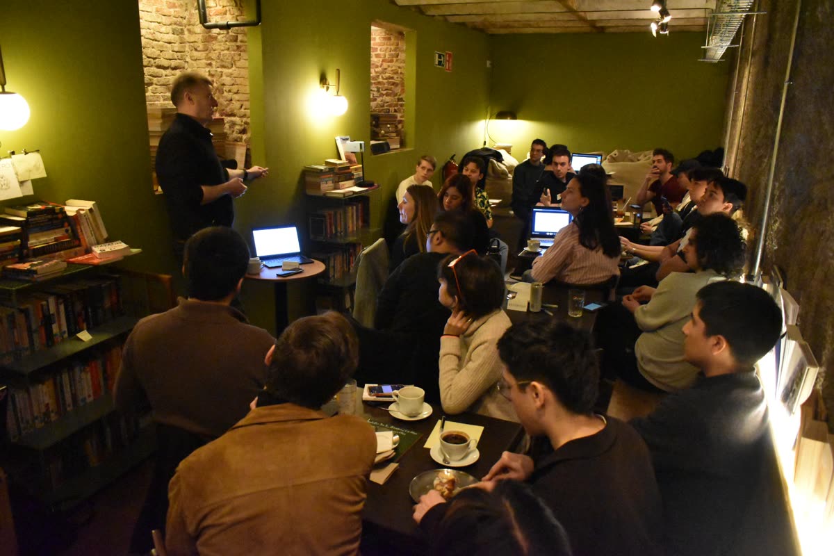A packed room listening to a speaker