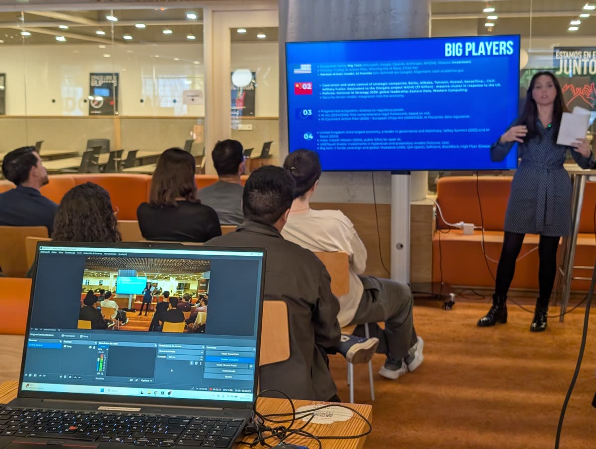 A talk in front of a screen, with the audience on sofas